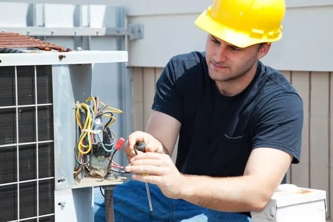 Technician testing connections on a residential heat pump